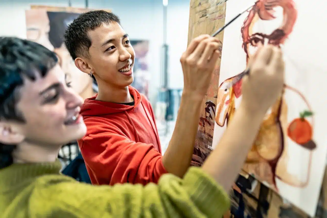 young-students-painting-on-canvas-during-lesson-in-faculty-of-arts-university